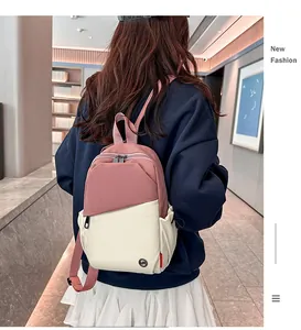 Detail of a pink and beige contrast mini backpack with metal zippers and side pockets