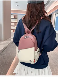 Detail view of a color-block backpack showing pink nylon straps and side storage pockets