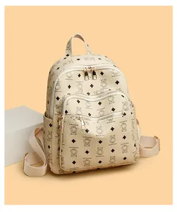 Detail of cream bear print backpack showing leather texture and gold-tone zippers