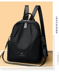 Détail d'un sac à dos plissé noir avec écusson logo en cuir et motif de kangourou
