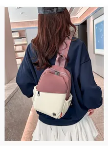 Detail view of pink and beige patchwork crossbody bag with wide strap on model