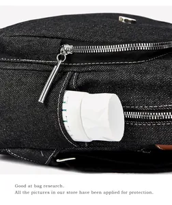 Detailed macro view showing the side pocket capacity and silver zipper of the denim bag