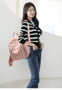 Detail of light pink PU backpack featuring cute bear prints and gold metal zippers