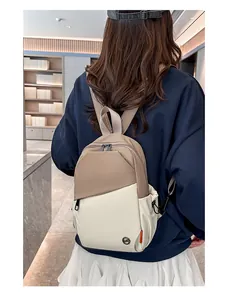 Close-up of contrast color backpack showing khaki nylon fabric and circular metal logo