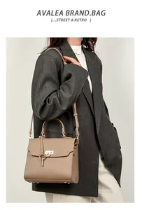 Detailansicht der khakifarbenen Lederhandtasche mit Goldverschluss und Bodennieten