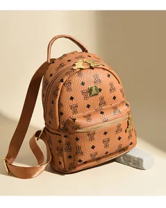 Detailopname van bruine leren rugzak met berenprint en goudkleurige metalen rits