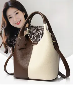 Detail of contrast stitching and lychee grain leather on a dual-tone bucket bag
