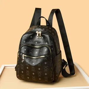Mini black backpack for women with bear print and golden zippers on orange background