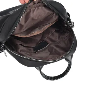 Intérieur du sac à dos en nylon noir avec doublure brune, poche zippée et fentes doubles