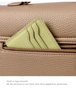 Detailansicht der braunen Leder-Handtasche mit hellgrünem Kartenetui und Reißverschluss