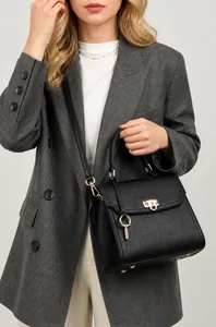 Nahaufnahme der schwarzen Lederhandtasche mit goldenem Schloss und Schultergurt