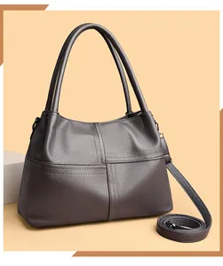 Detalle de la textura de cuero granulado y las costuras en el bolso tote color taupe