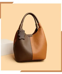 Close-up of litchi grain leather texture on a two-tone bucket bag with bear pendant