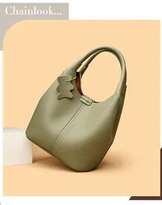 Detail of olive green pebbled leather bucket bag with matching bear bag charm