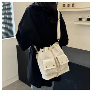 Detail van witte emmertas met trekkoord, voorzakken en zilveren studs afwerking