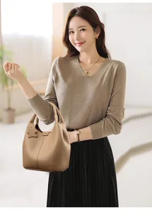 Brown litchi grain leather bucket bag shown on a model with a star charm detail