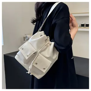 Detail van de witte Oxford bucket bag met trekkoord en zakken gedragen door een model