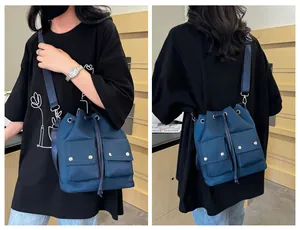 Donkerblauwe nylon emmertas met handige vakken en brede riem op het model