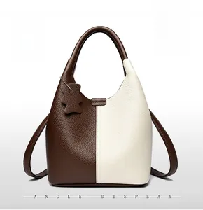 Detail of two-tone leather tote bag with pebble texture and cute bear charm