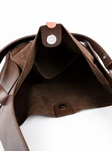 Detailed inner view of brown suede bucket bag featuring magnetic closure and pockets