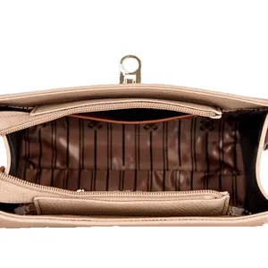Draufsicht auf das Innere der rosa Ledertasche mit Reißverschlussfächern und goldenen Beschlägen