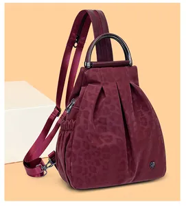 Details des weinroten Rucksacks mit Leopardenmuster, Faltenstruktur und Metallblume