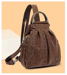 Detail der Leoparden-Prägung auf einem braunen Reiserucksack mit Blumenlogo aus Metall
