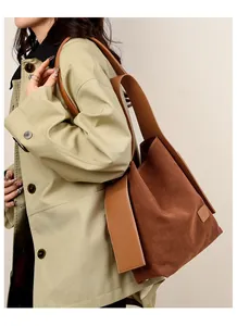 Detail view of brown suede bucket bag texture and leather strap on a trench coat