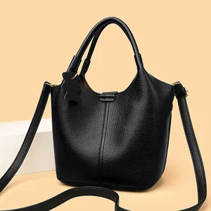 Chic black litchi grain leather bucket bag with top handle and cute bear charm