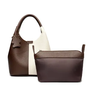 Two-piece leather handbag set in brown and off-white with cute bear charm and bucket shape