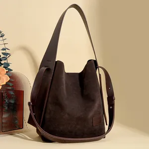 Retro dark brown suede bucket bag with leather strap and minimalist vintage design