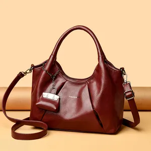 Borsa a mezzaluna in pelle plissettata bordeaux con tracolla e mini ciondolo decor