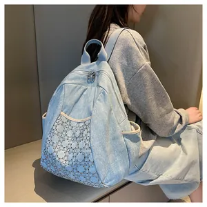 Detail of light blue denim backpack featuring quilted rhinestone pattern and sturdy zippers