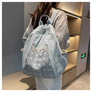 Detail of light blue denim backpack with sparkling rhinestone lattice pattern and top handle