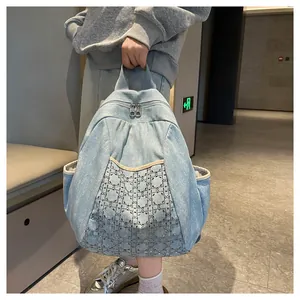 Close-up of light blue denim backpack with geometric diamond pattern and sparkling rhinestones