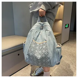 Detail view of denim backpack featuring embroidered geometric diamond rhinestones and studs