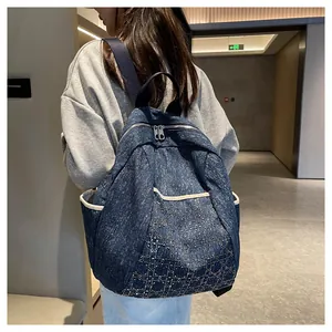 Detailed back view of large blue denim backpack with diamond quilted stitching detail