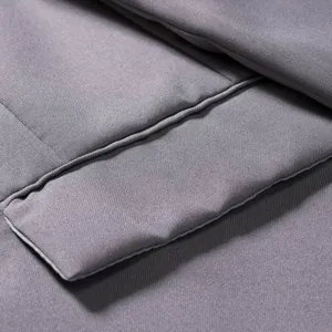 Close-up of grey quilted blazer fabric showing refined texture and durable stitching