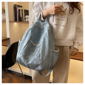 Close-up of light blue denim backpack with diamond studded cannage pattern and zippers