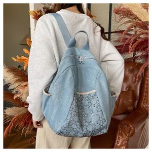 Detail of light blue denim backpack with silver rhinestone diamond pattern and side pockets
