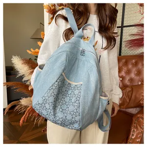 Detail of light blue denim backpack with silver sequin geometric patterns on a model