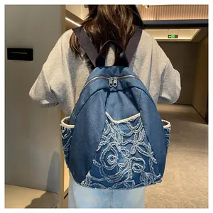 Detail shot of blue denim backpack with floral embroidery and rhinestone embellishments