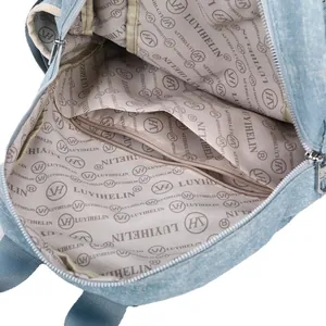 Light blue denim backpack interior detail with logo lining and zip pocket