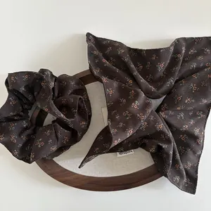 Brown floral scrunchie and hair scarf set with handmade label on a wooden frame