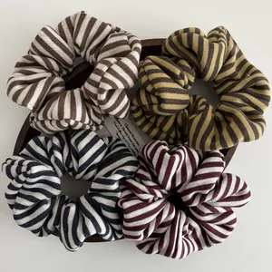 Striped knit scrunchies in retro colors like brown, yellow, black and burgundy on a tray
