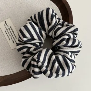 Detailed view of large black and white striped knit scrunchie with soft cotton texture