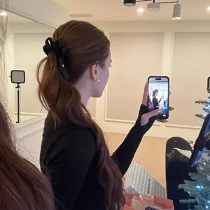 Barrette à cheveux élégante à nœud en satin noir sur une queue de cheval brune