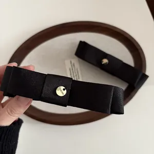 Serre-tête élégant en satin noir avec détail doré MORAVA pour un style sophistiqué