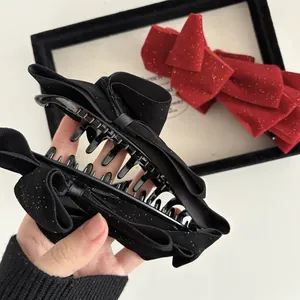 Elegant double-layered bow hair claw with gold shimmer in black and festive red colors