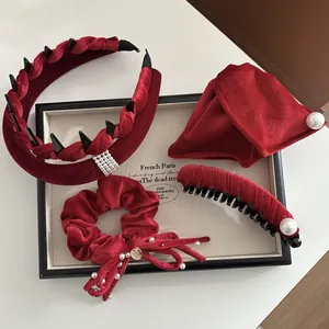 Set di accessori per capelli in velluto rosso con perle e borchie su vassoio bianco